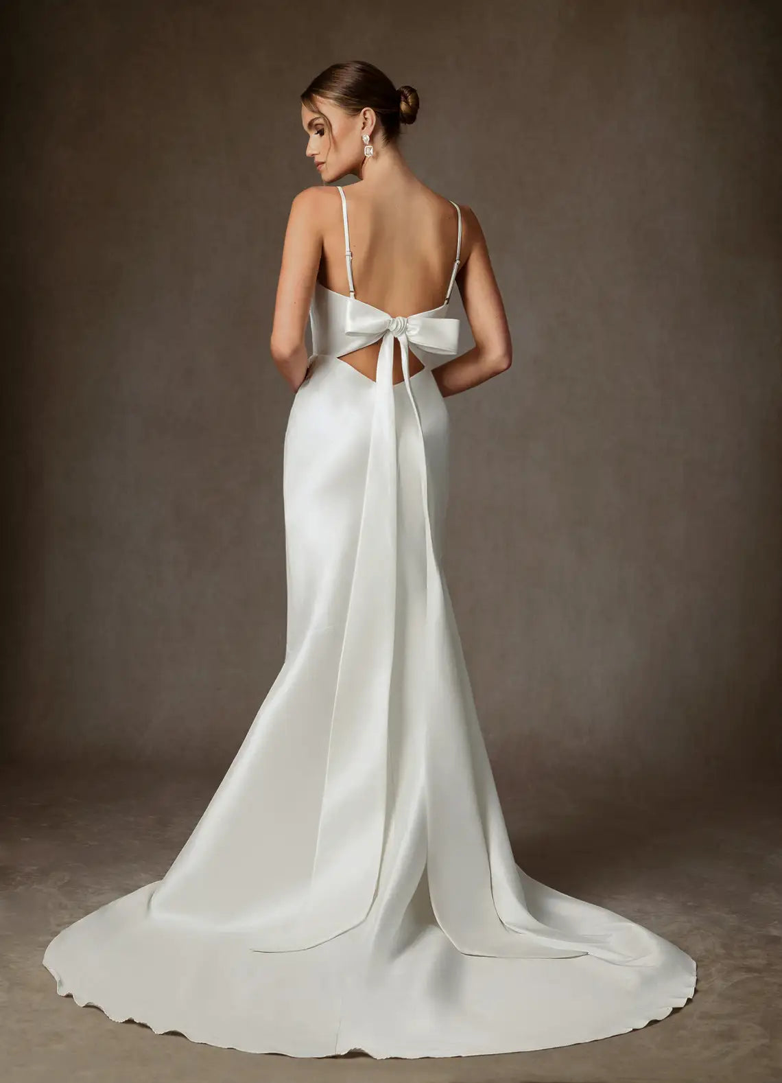 Luxurious smooth satin constructionElegant satin mermaid gown featuring a cowl neckline, thin spaghetti straps, and a dramatic bow back detail.Satin Cowl Neck Mermaid Wedding Dress with Bow Back